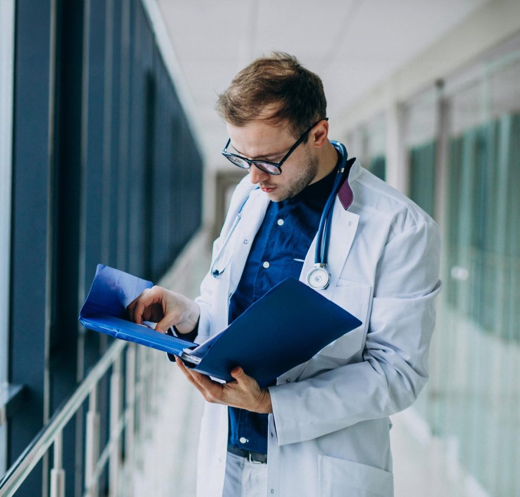 Um médico concentrado, estudando documentos médicos