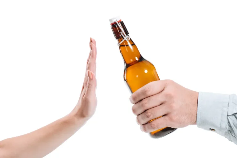 Mão oferecendo uma garrafa de cerveja enquanto outra mão faz gesto de recusa.