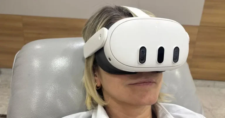 Mulher loira sentada em poltrona clínica usando óculos de realidade virtual branco durante atendimento no IOP.