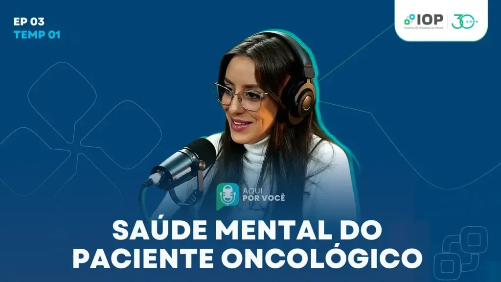 Mulher usando fones e falando ao microfone em estúdio de podcast sobre saúde mental do paciente oncológico
